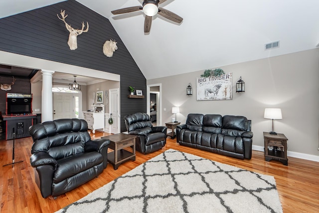 living area with ceiling fan, wood finished floors, visible vents, baseboards, and decorative columns