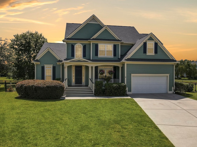 craftsman inspired home with covered porch, a garage, and a lawn