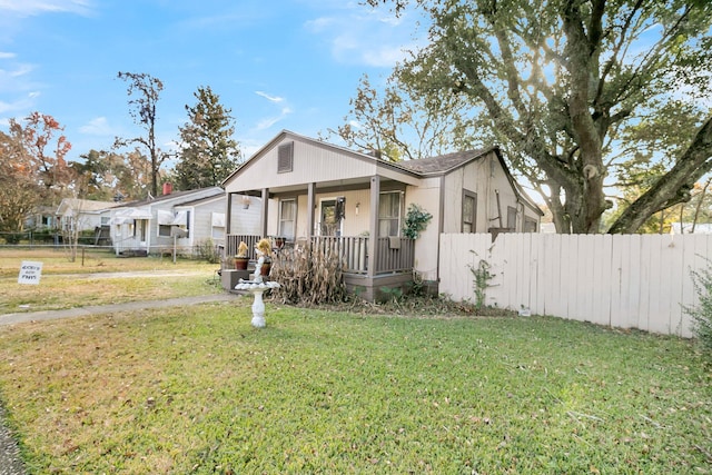 view of front of house featuring covered porch and a front lawn