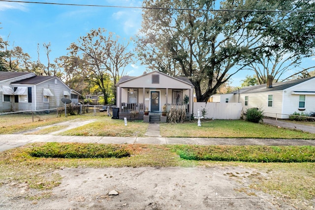 bungalow-style home featuring covered porch and a front yard