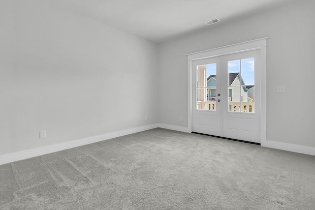 empty room featuring light carpet and french doors