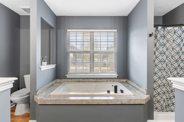 bathroom featuring shower with separate bathtub, hardwood / wood-style flooring, and toilet