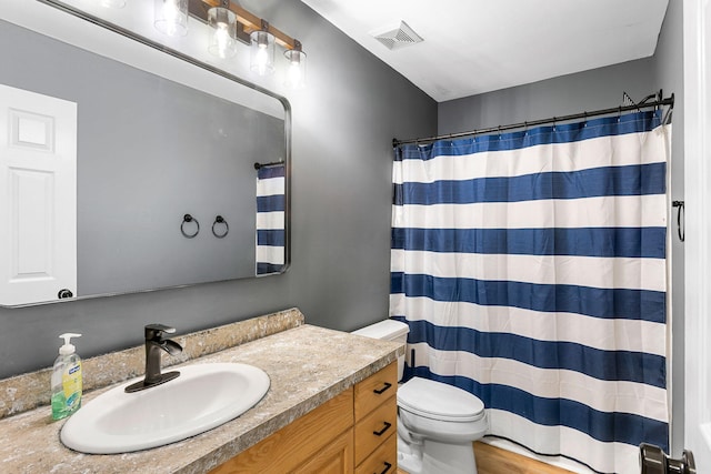 bathroom featuring walk in shower, wood-type flooring, vanity, and toilet