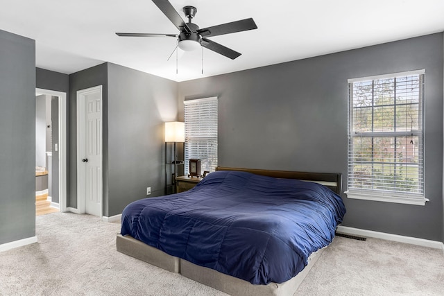 carpeted bedroom with ceiling fan and ensuite bathroom