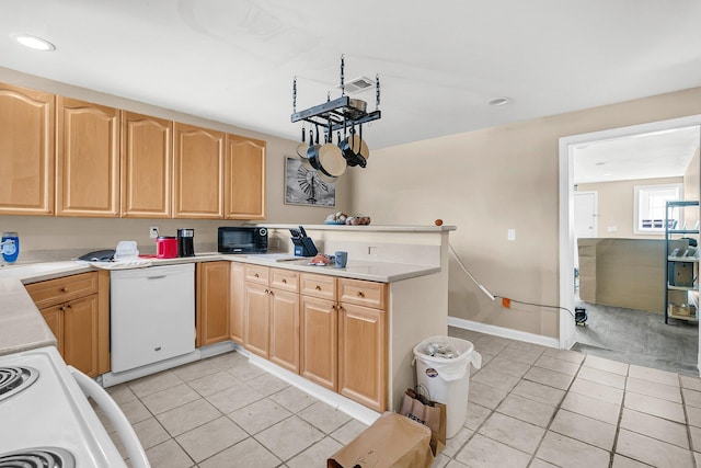 kitchen with dishwasher, range with electric cooktop, light tile patterned floors, and light brown cabinets