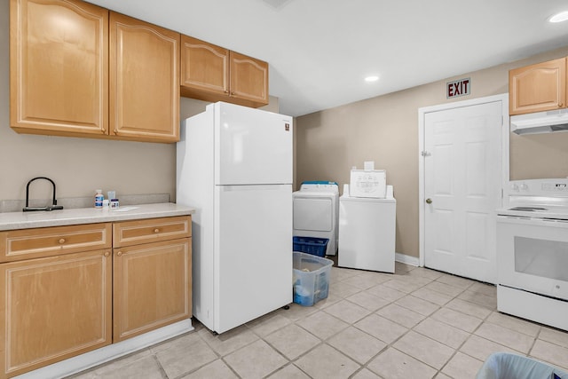 kitchen with light tile patterned floors, white appliances, washer and dryer, and light brown cabinets