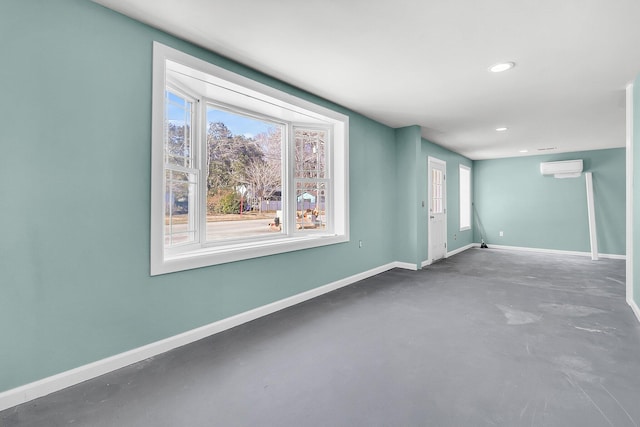 empty room featuring a wall mounted air conditioner and concrete flooring