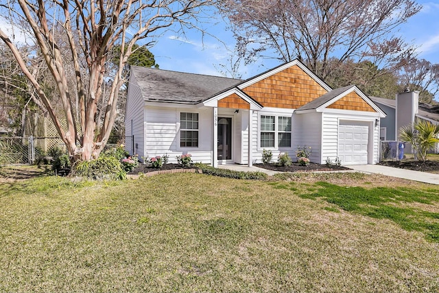 view of front facade featuring an attached garage, fence, driveway, roof with shingles, and a front yard