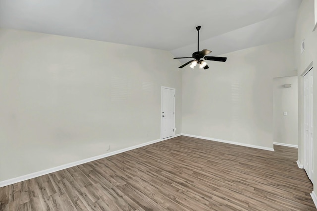 empty room featuring a ceiling fan, high vaulted ceiling, baseboards, and wood finished floors