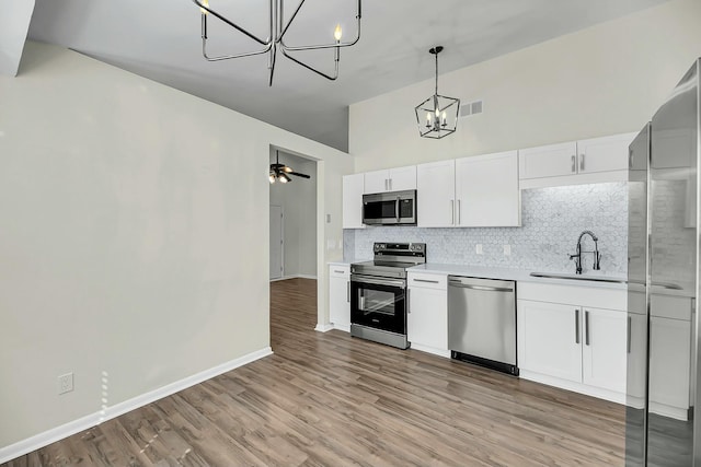 kitchen featuring visible vents, appliances with stainless steel finishes, a sink, light countertops, and backsplash