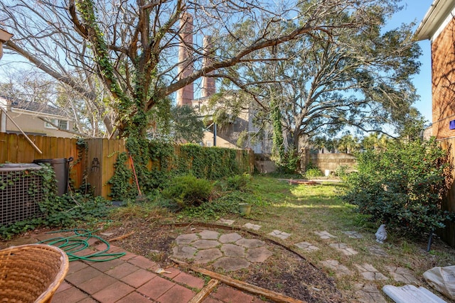 view of yard with a fenced backyard and central AC unit