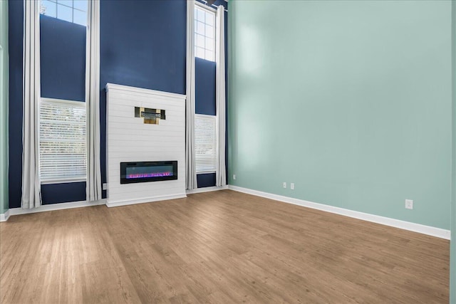 unfurnished living room with a high ceiling and light hardwood / wood-style flooring