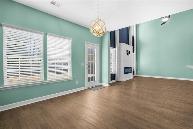 unfurnished living room with dark hardwood / wood-style floors and a notable chandelier