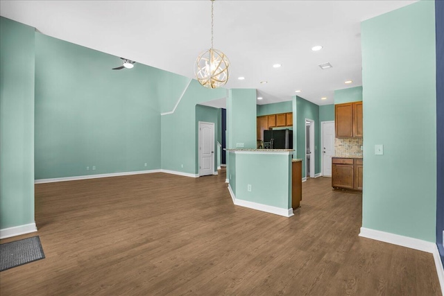 kitchen featuring pendant lighting, black refrigerator with ice dispenser, an inviting chandelier, dark hardwood / wood-style floors, and decorative backsplash