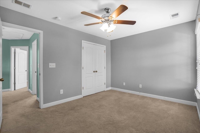 unfurnished bedroom with ceiling fan, a closet, and light colored carpet