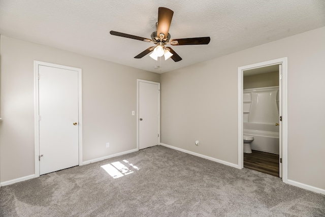 unfurnished bedroom with ensuite bath, a textured ceiling, light colored carpet, and ceiling fan