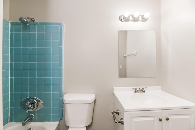 full bathroom featuring tiled shower / bath, vanity, and toilet