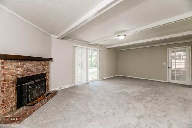 unfurnished living room with a textured ceiling, carpet flooring, ornamental molding, beamed ceiling, and a fireplace