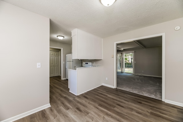 kitchen featuring white electric range, white cabinetry, a textured ceiling, and dark hardwood / wood-style flooring