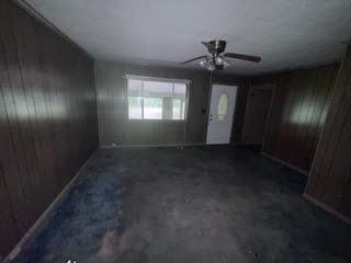 838 Ranch Hill Ln, Saint Stephen, SC 29479 - foyer with concrete flooring, wood walls, and a ceiling fan