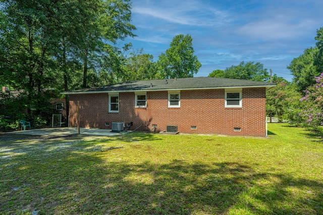 rear view of house with a lawn, a patio area, and central AC unit