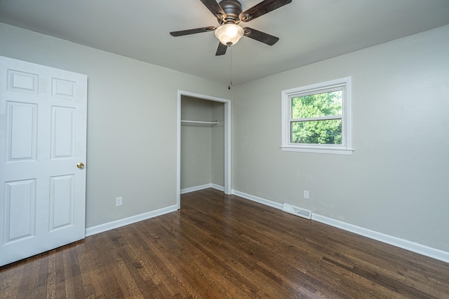 unfurnished bedroom featuring dark hardwood / wood-style flooring, ceiling fan, and a closet