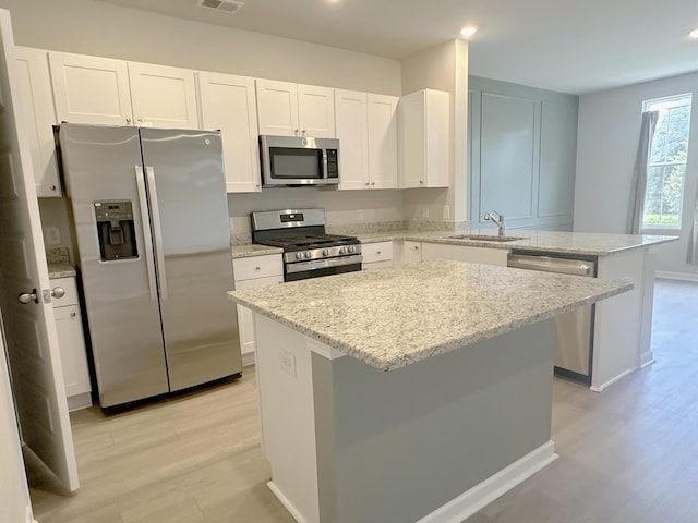 1443 Central Ave, Summerville, SC 29483 - kitchen featuring appliances with stainless steel finishes, a sink, light wood finished floors, a peninsula, and a center island