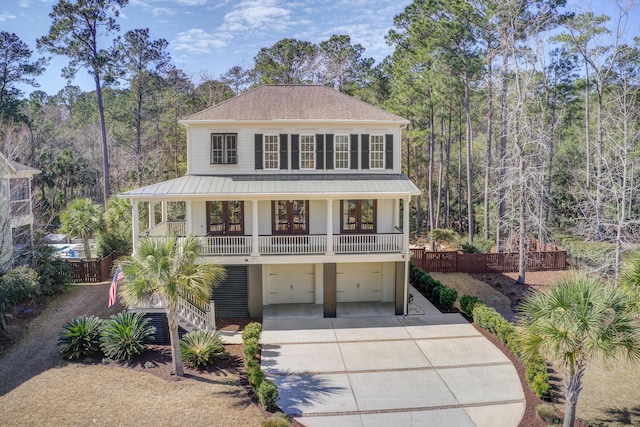 view of front of house with driveway, a garage, stairway, fence, and a porch