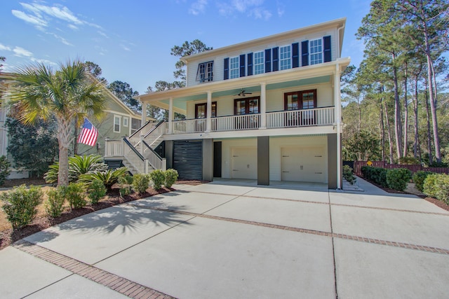 view of front facade with a garage, covered porch, driveway, and stairs