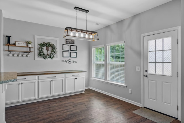9923 Honeylocust Ln, Ladson, SC 29456 - unfurnished dining area with dark wood-type flooring, a chandelier, and baseboards