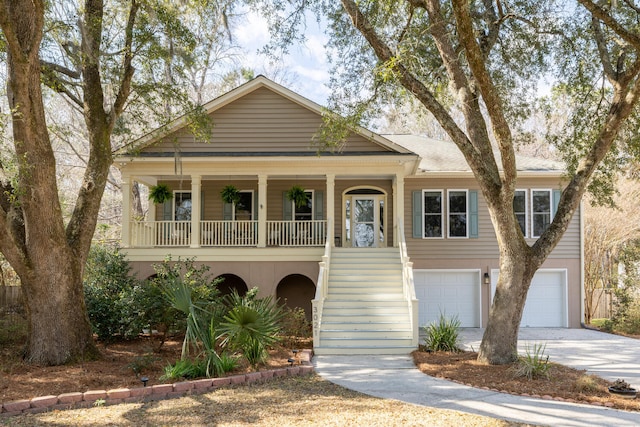 view of front of property featuring stucco siding, covered porch, concrete driveway, a garage, and stairs