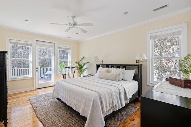 bedroom with ornamental molding, light wood-style flooring, visible vents, and access to exterior