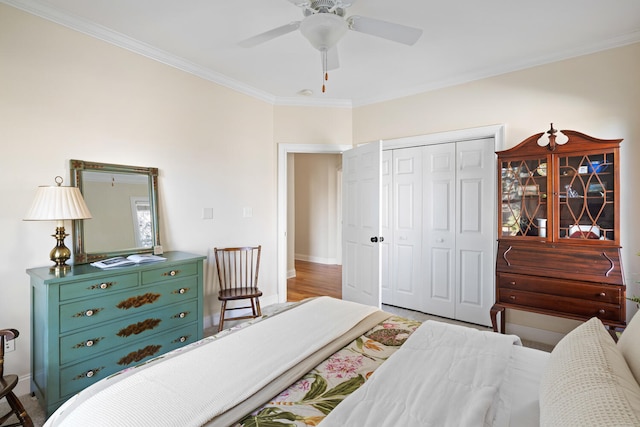 bedroom featuring wood finished floors, a ceiling fan, baseboards, a closet, and crown molding