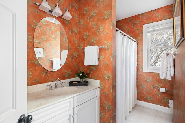 bathroom with vanity, baseboards, and wallpapered walls