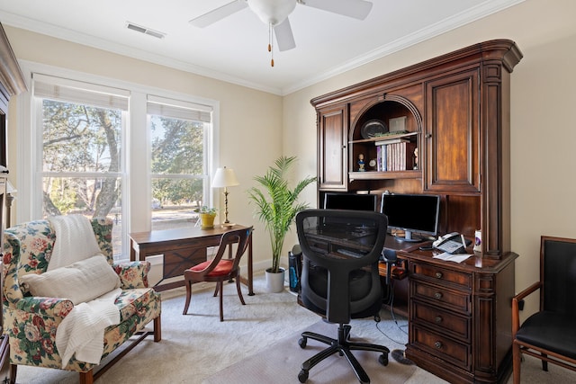 home office featuring light colored carpet, a ceiling fan, baseboards, visible vents, and ornamental molding