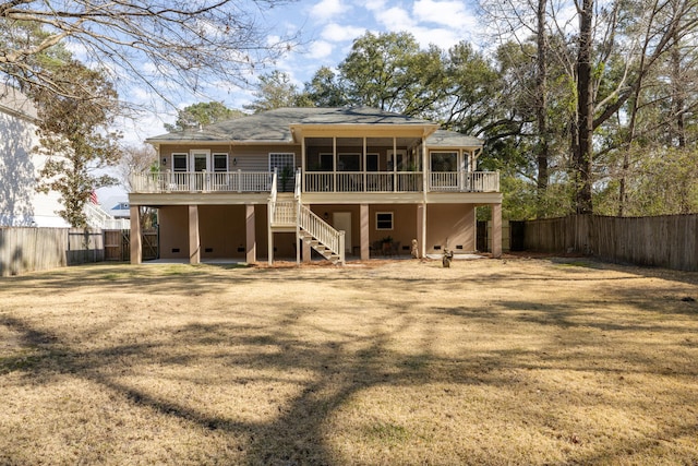 rear view of property featuring a deck, a fenced backyard, crawl space, stairway, and a lawn