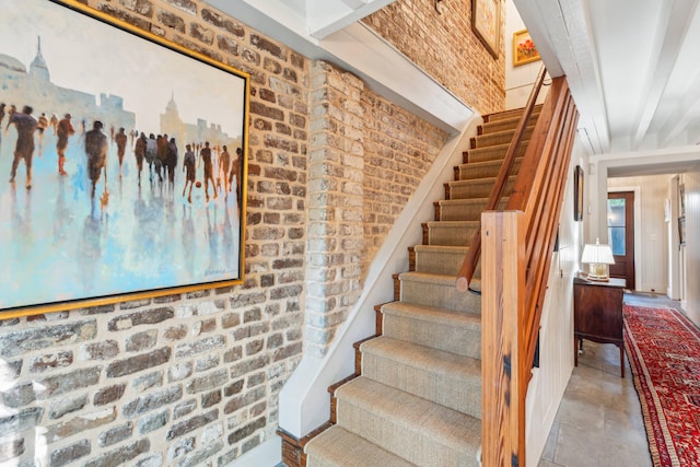 stairway featuring brick wall