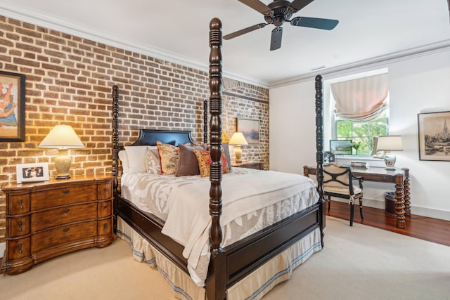 bedroom featuring light hardwood / wood-style floors, brick wall, ceiling fan, and crown molding