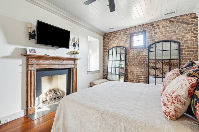 bedroom with wooden ceiling, hardwood / wood-style flooring, ceiling fan, and brick wall