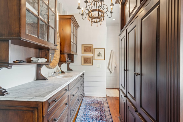 mudroom featuring dark wood-type flooring, an inviting chandelier, and sink