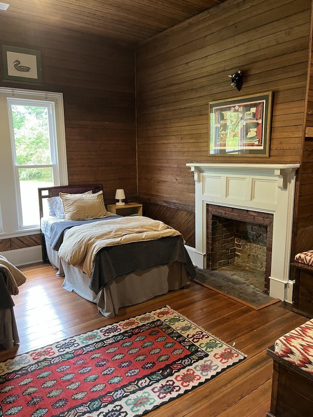 5924 Wagener Rd, Wagener, SC 29164 - bedroom featuring wooden walls, hardwood / wood-style floors, and a fireplace with flush hearth