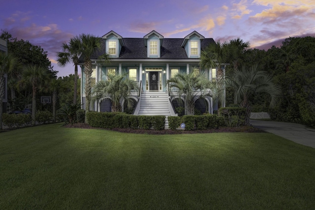 view of front facade featuring stairway and a lawn