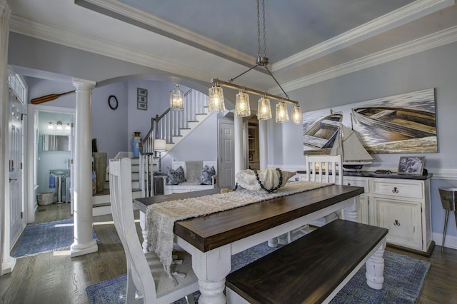 dining space featuring arched walkways, a raised ceiling, stairway, dark wood-type flooring, and ornate columns