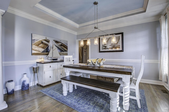 dining area featuring dark wood-style flooring, a raised ceiling, and baseboards