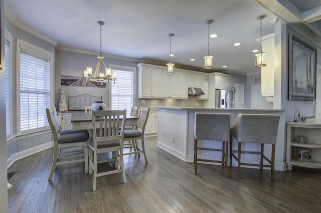 dining room with dark wood-type flooring, a chandelier, crown molding, and baseboards