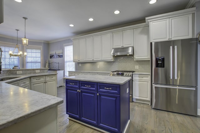 kitchen with stainless steel appliances, a kitchen island, white cabinetry, and under cabinet range hood