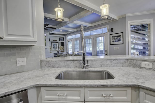 kitchen with white cabinets, a sink, and hanging light fixtures