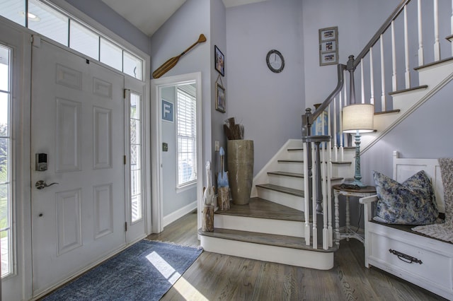 entrance foyer with dark wood-style flooring, stairway, and baseboards