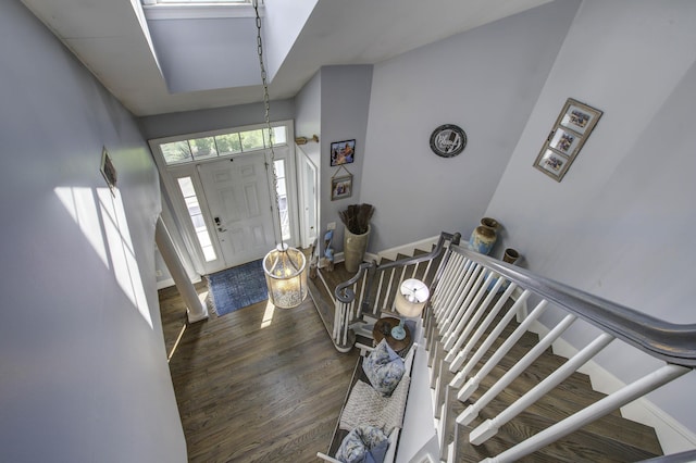 foyer featuring dark wood finished floors, stairway, and baseboards