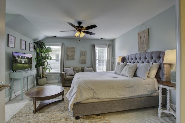 carpeted bedroom featuring vaulted ceiling, multiple windows, a ceiling fan, and baseboards